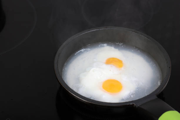 istock Poached eggs in frying pan on Induction Cooker 1455480425