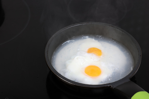 Poached eggs in frying pan on Induction Cooker