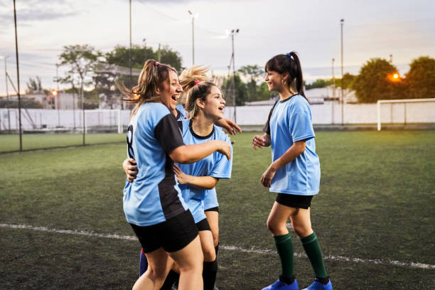 allegro calcio femminile che celebra un gol sul campo sportivo - child celebration cheering victory foto e immagini stock