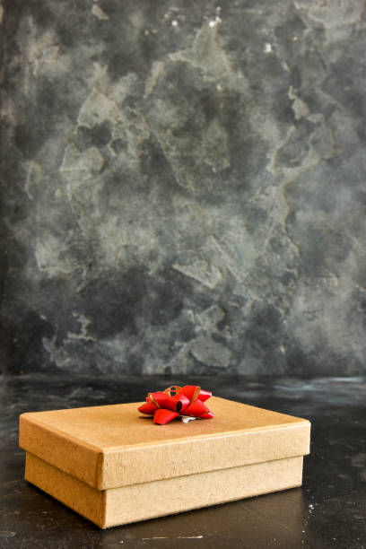 istock Gift  box on a  black background, decorated with a textured bow and feathers,creating a romantic atmosphere for anniversary presents,valentine and birthday gift, post cards. Close up, copy space 1455482736