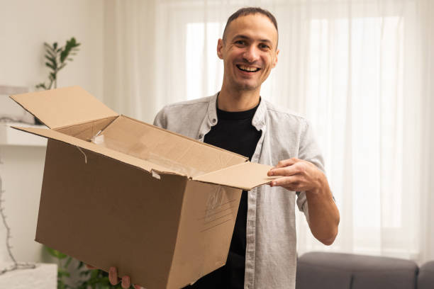 istock happy cheerful man hold hand boxes smile move houses 1455482947