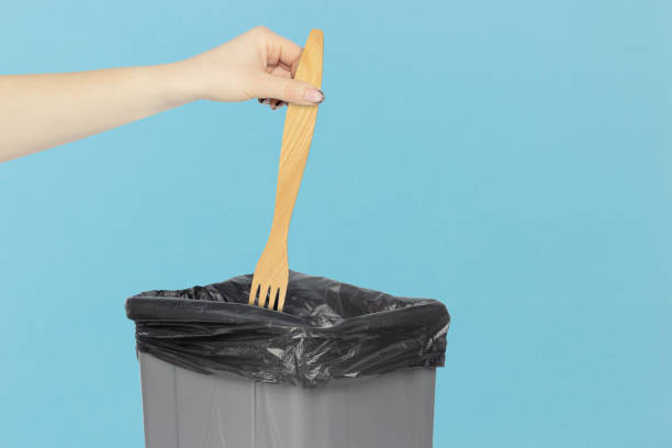 istock throw wooden fork in trash can, fork in hand in front of trash can, diet concept 1455489144