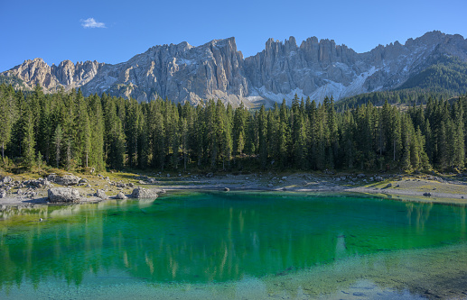 View over the lake Carezza (Italian: Lago di Carezza; German: Karersee) with the Latemar mountain range in the background. It is located in the Dolomites, European Alps, Italy.