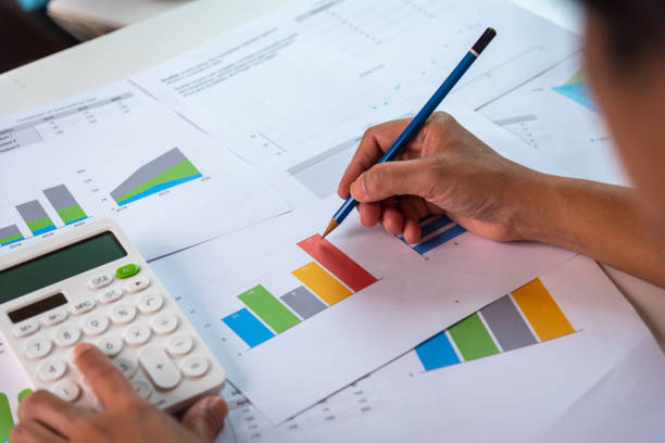 istock Hand writes down something while using calculator, sitting at the laptop at home for study, audit, remote work, accountant, calculator, count, business, work from home concept. 1455492210