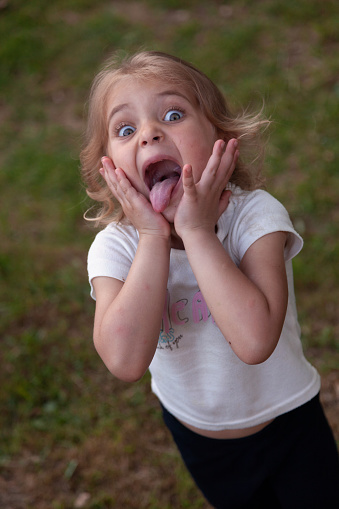 Portrait of a little girl making a face in the park