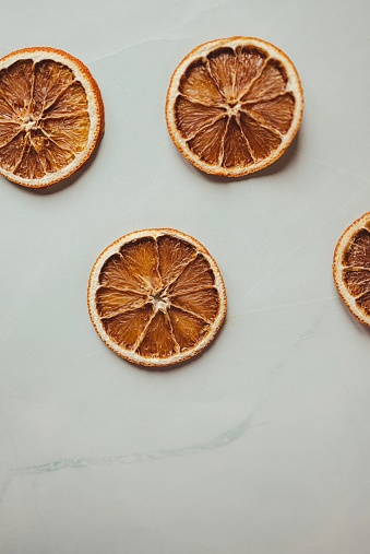 Istanbul, Turkey-January 4, 2023: Dried orange slices on a gray marble background. Shot with Canon EOS R5.