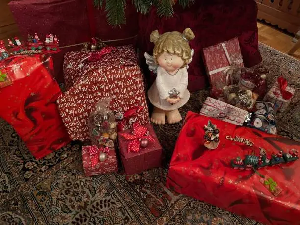 Acht Weihnachtsgeschenke mit Dekoration und kleiner Engelsgigur