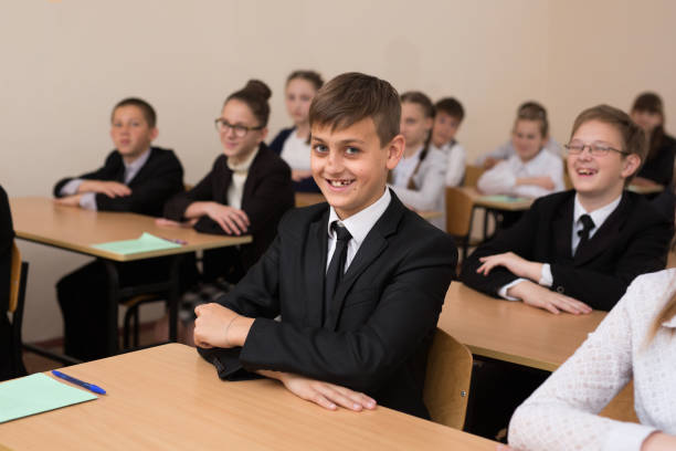 istock Happy schoolchildren sit at a desk in the classroom. 1455499653