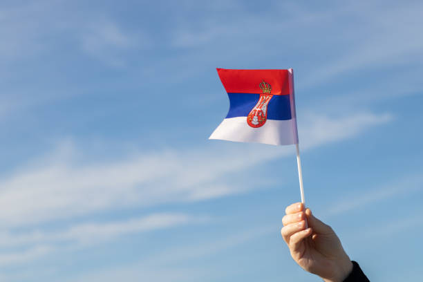 istock Serbian flag in hand flutters in the wind against the sky 1455499752