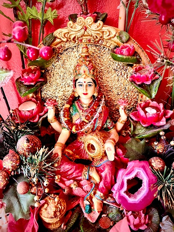 Indische Göttin Lakshmi mit Blumenaltar, Nahaufnahme, Glücksbringer, Brunnen, Altar