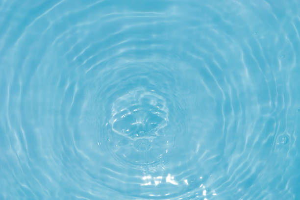 istock Defocus blurred transparent blue colored clear calm water surface texture with splashes and bubbles. Trendy abstract nature background. Water waves in sunlight with caustics. Blue water shinning 1455499950