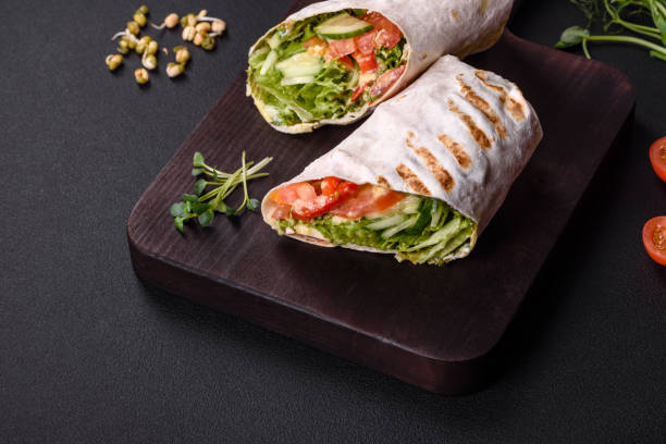 istock Delicious fresh shawarma with tomatoes, peppers, cucumber on a dark concrete background 1455500334