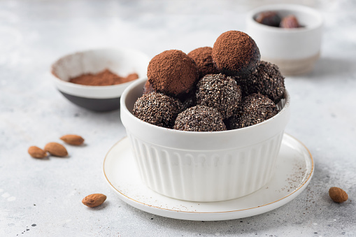 Vegan energy balls with dates, almonds, chia seeds in white bowl. vegan alternative food. copy space