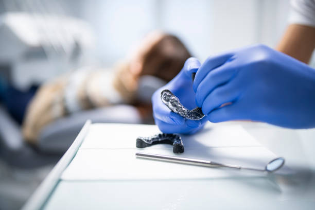 Close up of male orthodontist preparing aligners for his patient.