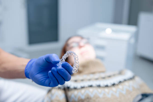 istock Hands of dentist holding dental aligner. 1455501414