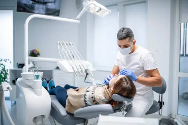 Photo of Dentist examining female patient.