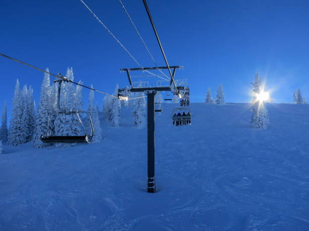 People on ski lift with early morning sun on the horizon. Steamboat ski resort, Colorado stock photo