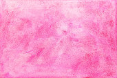 Pink and red watercolor paint on paper background.