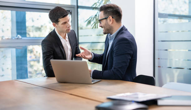 istock Two businessmen working with laptop at meeting in office 1455506100