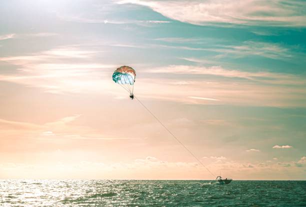 Parasailing at sunset in Clearwater Beach Florida People parasailing at sunset in Clearwater Beach Florida parasailing stock pictures, royalty-free photos & images