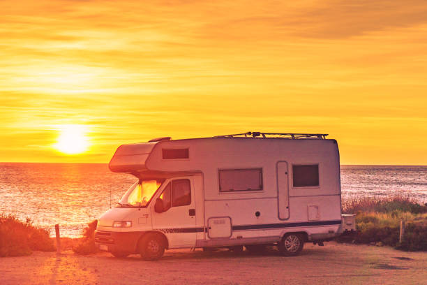 istock Camper car on beach at sunrise 1455507381