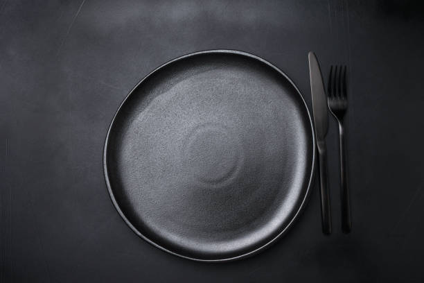 istock Background for menu Empty Black craft plat knife fork on dark stone table. Top view, copy space, Table setting. background for menu, layout, place for text , recipe background 1455509033