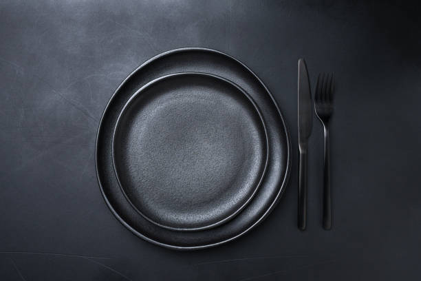 istock Background for menu Empty Black craft plat knife fork on dark stone table. Top view, copy space, Table setting. background for menu, layout, place for text , recipe background 1455509034