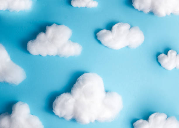 Pattern of white fluffy clouds made of cotton wool on a blue background Pattern of white fluffy clouds made of cotton wool on a blue background cotton cloud stock pictures, royalty-free photos & images