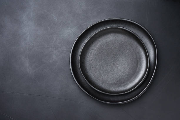istock Background for menu Empty Black craft plat knife fork on dark stone table. Top view, copy space, Table setting. background for menu, layout, place for text , recipe background 1455509149