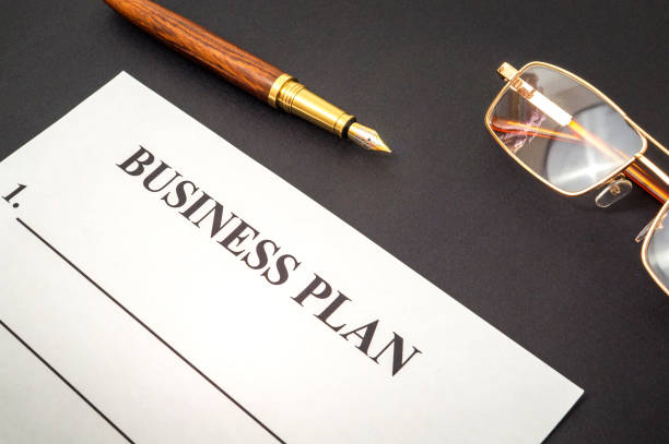 istock Blank form and pen, glasses for drawing up business plan on black table 1455510278