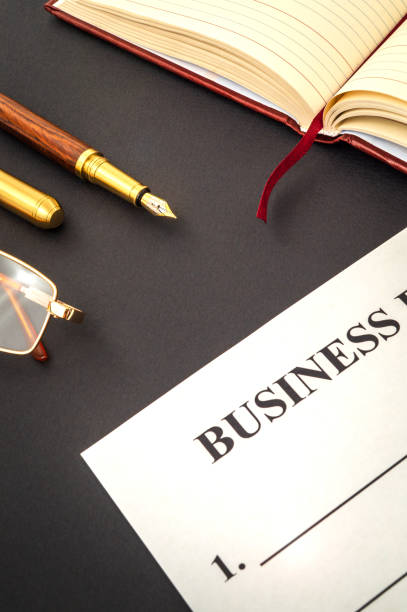 istock Blank form and pen, glasses for drawing up business plan on black table 1455510319