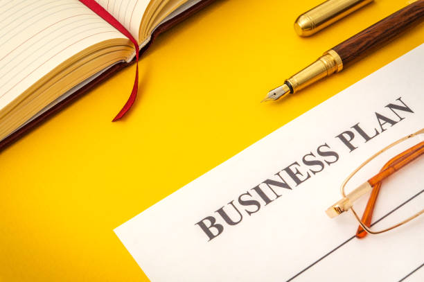istock Blank form and pen for drawing up business plan on yellow table 1455510320