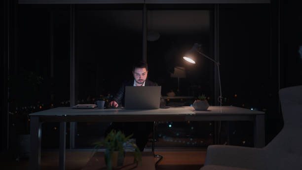 istock Young businessman working late at office at night 1455519413