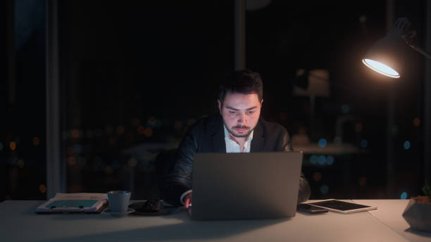 istock Young businessman working late at office at night 1455519494
