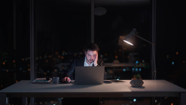 istock Young businessman working late at office at night 1455519553