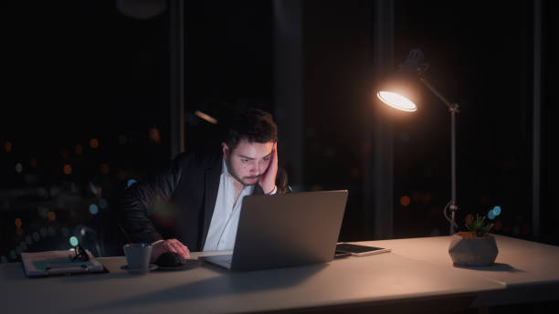 istock Young businessman working late at office at night 1455519630