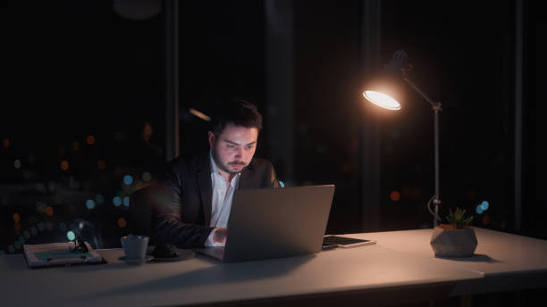 istock Young businessman working late at office at night 1455519694