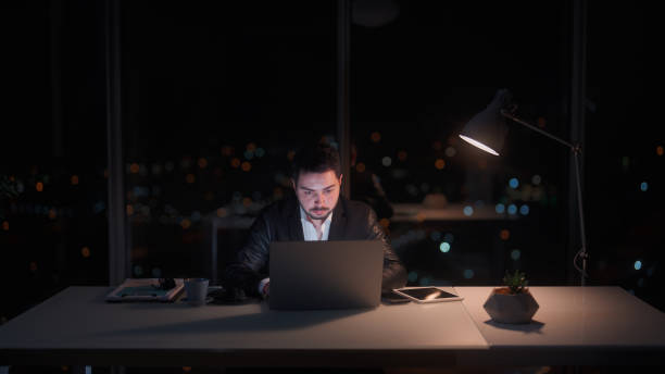 istock Young businessman working late at office at night 1455519736