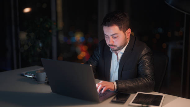 istock Young businessman working late at office at night 1455519773