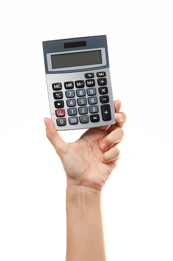 Person is holding a calculator in hand in front of pure white background.