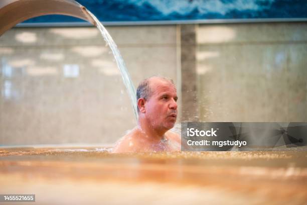 Man Enjoying A Jet Of Hot Thermal Water Stock Photo - Download Image Now - Wellbeing, 50-54 Years, Active Lifestyle