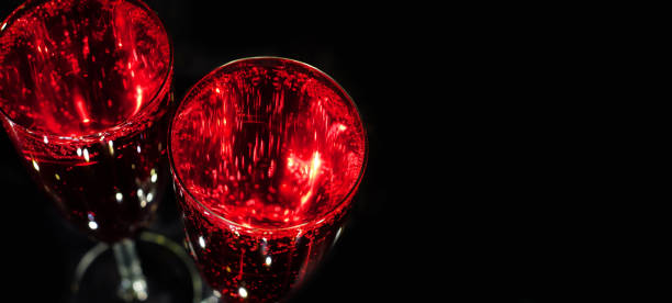 istock Glasses with red sparkling drink above on black background with copy space 1455522738