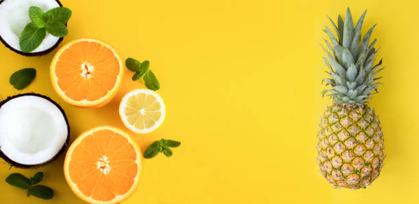 istock Pineapple, orange, lemon and coconut on the yellow background. Copy space. Top view. 1455523428