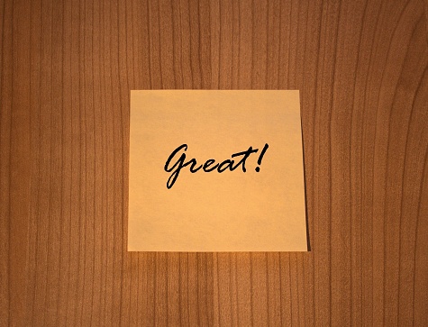 Post-it note message Great! on wooden Background
