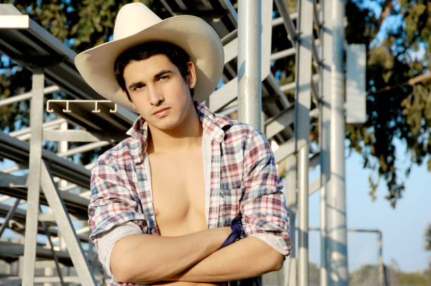 istock Young hispanic cowboy showing off his chest. 1455527442
