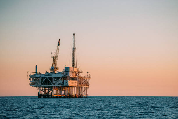 plataforma de petróleo offshore em sunset off huntington beach, califórnia - oil rig sea oil well oil drill - fotografias e filmes do acervo