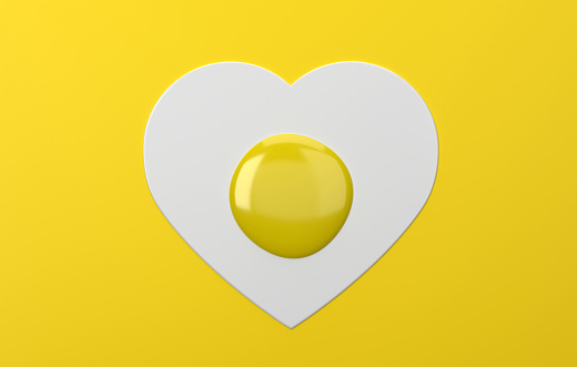 Heart shaped fried egg on yellow background. Valentines Day Background