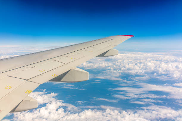 istock View from the airplane window at a beautiful cloudy sky and the airplane wing 1455529094