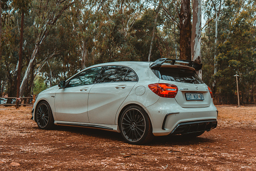 Irene, South Africa – October 02, 2021: A view of a white Mercedes Benz AMG A45 car in a forest