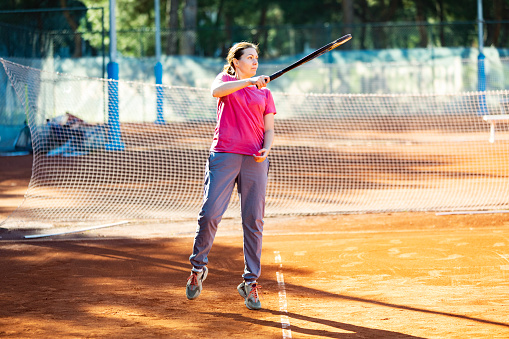Young adult woman learning to play tennis